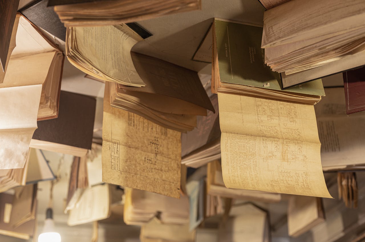 Artistic installation of open books hanging from a ceiling, creating a surreal reading ambiance.