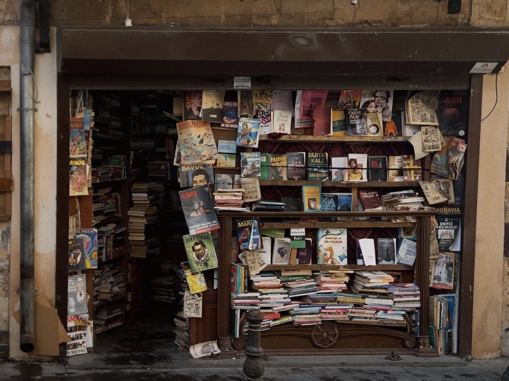 A front view of an old bookstore with a vibrant and eclectic mix of books and posters.